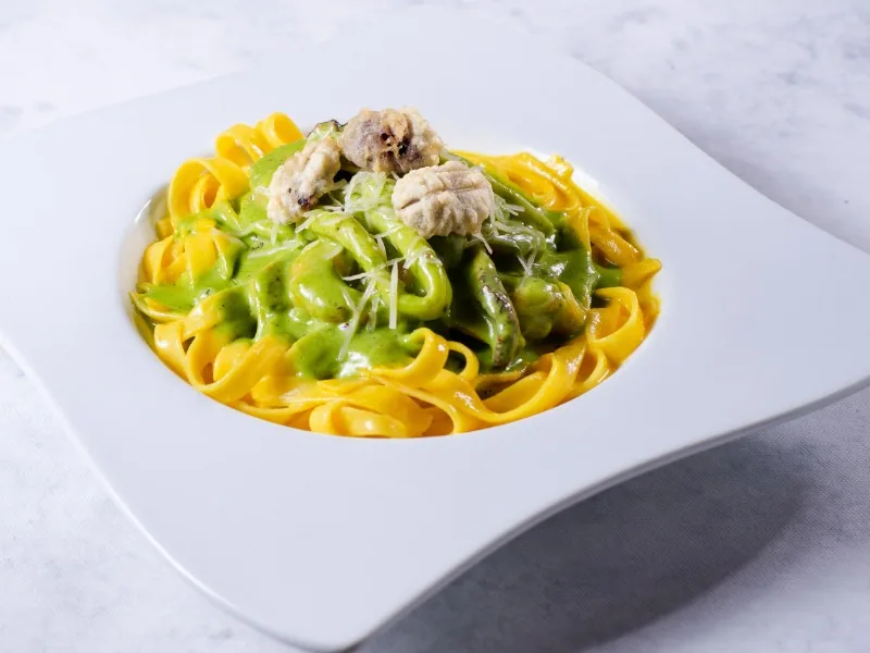 Fettuccine huancaína con mariscos en pesto