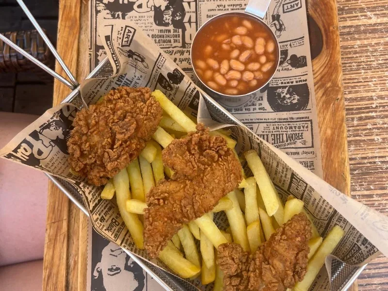 3 piezas de pollo frito sureño con papas fritas y frijoles.