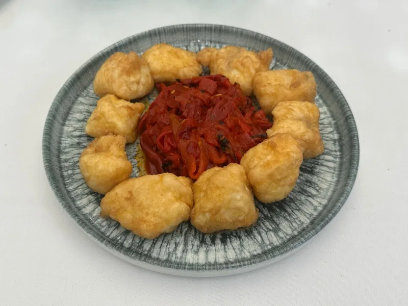 Dados de merluza frita con pilpil de pimientos